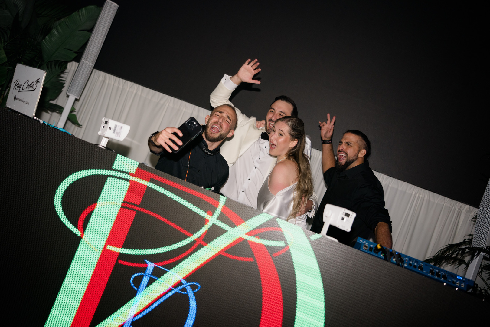 Thomas Thorogood in the DJ booth with a bride and groom during a live event production.